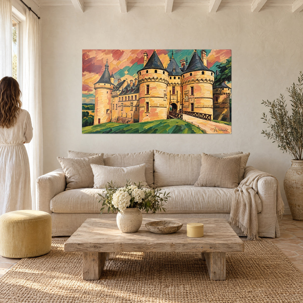 Gemälde Festung von Chaumont mit runden ockerfarbenen Türmen, dunklen Schieferdächern, rosa und türkisfarbenem Himmel, über einem Sofa in einem lichtdurchfluteten Wohnzimmer