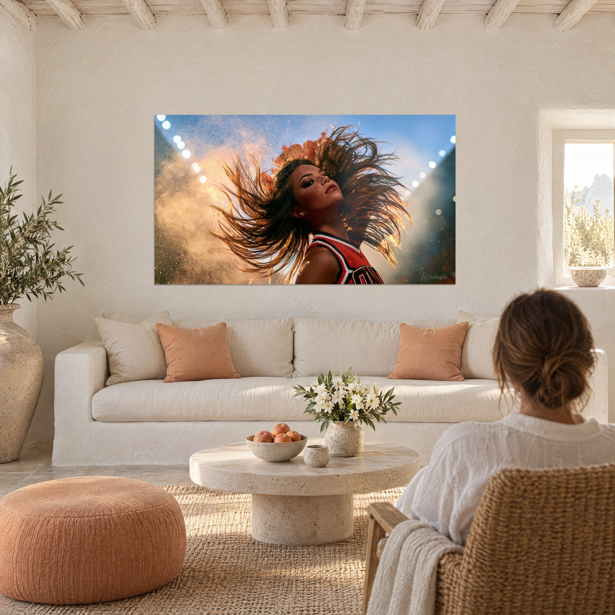 Wall art cheerleader with chestnut highlights swept up in motion, blue sky and golden dust, above a sofa in a bright living room