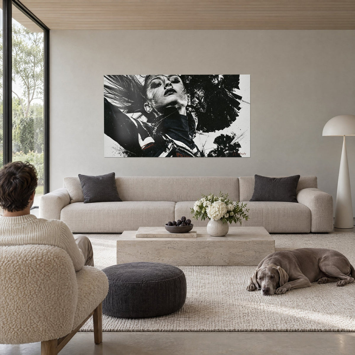 Gemälde Gesicht einer kopfüber stehenden Cheerleaderin, schwarze Lippen und peitschendes Haar, schwarzweiß, über einem Sofa in einem lichtdurchfluteten Wohnzimmer