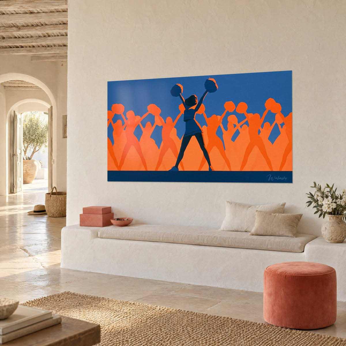Quadro cheerleader con gonna plissettata blu navy, folla di sagome arancioni su sfondo blu reale, appeso vicino a una panca in pietra