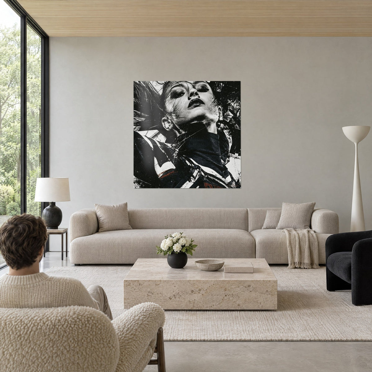 Quadro volto capovolto dalle labbra nere, schizzi di inchiostro nero e bianco crema, sopra un divano in un soggiorno luminoso