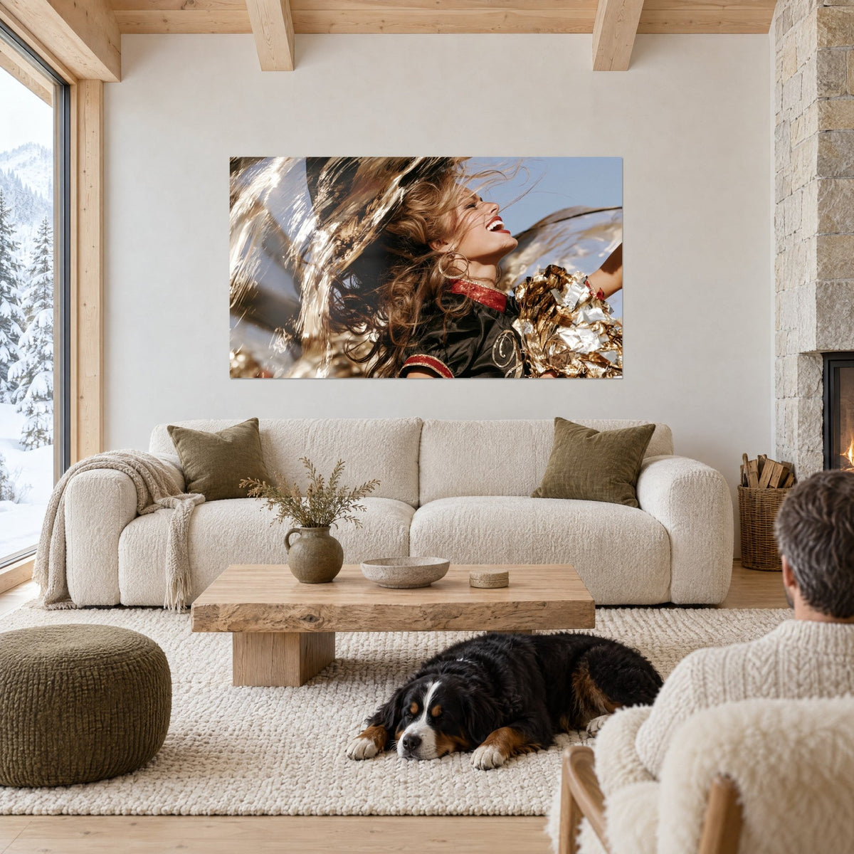 Wall art of a laughing cheerleader with windswept brown hair and gold pom-poms, above a sofa in a bright living room