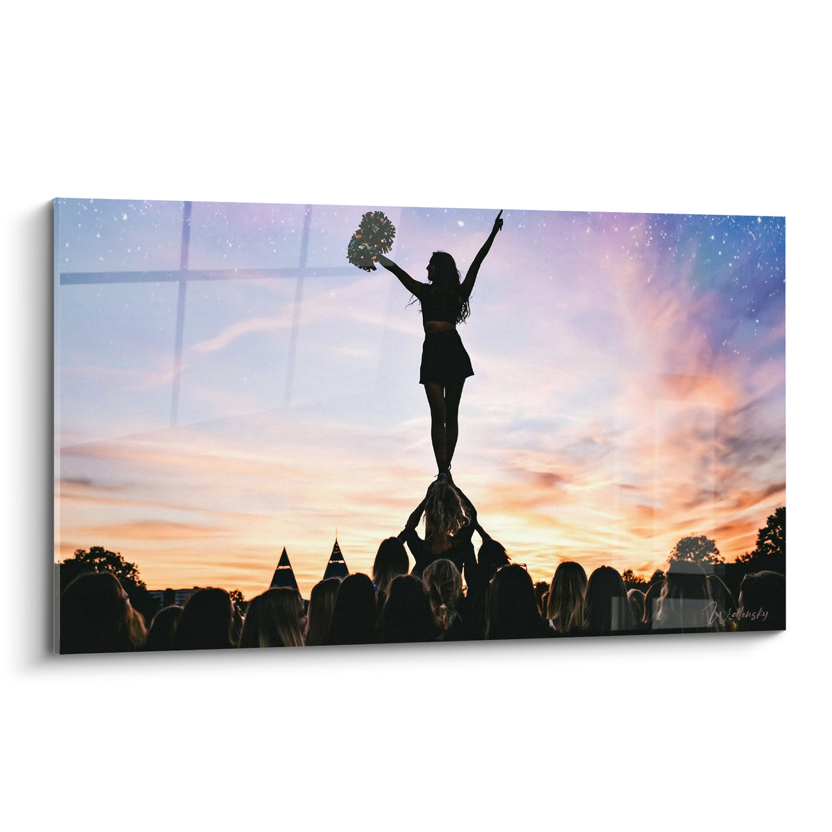 Pom-pom girl en silhouette anthracite, bras levés, sur ciel orange et violet étoilé