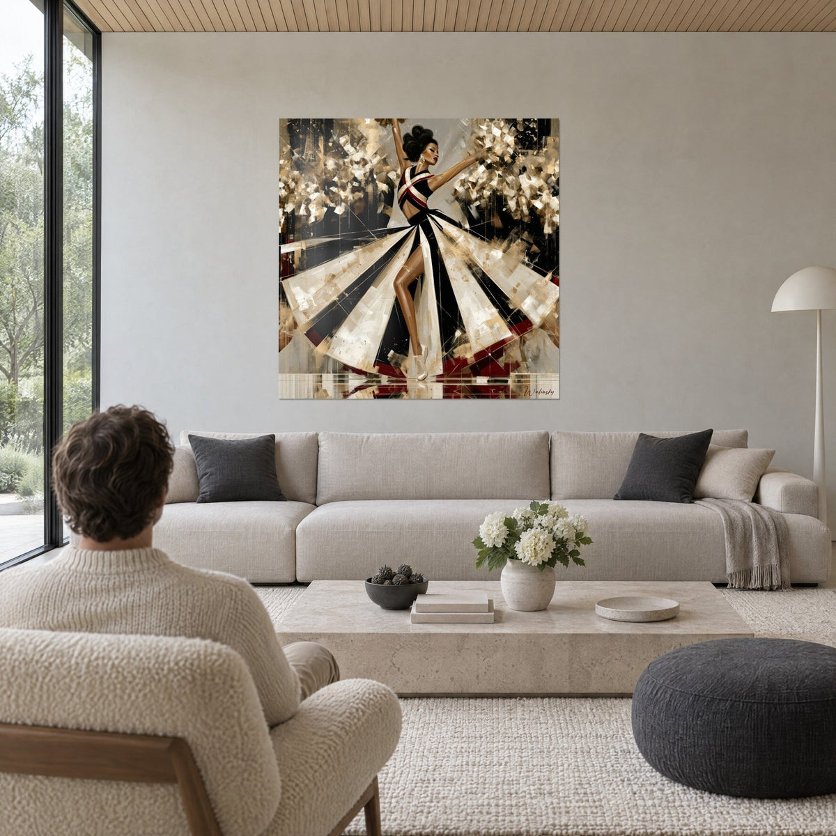 Tableau danseuse élancée en jupe noire et ivoire déployée en éventail, pompons dorés, au-dessus d'un canapé dans un salon lumineux