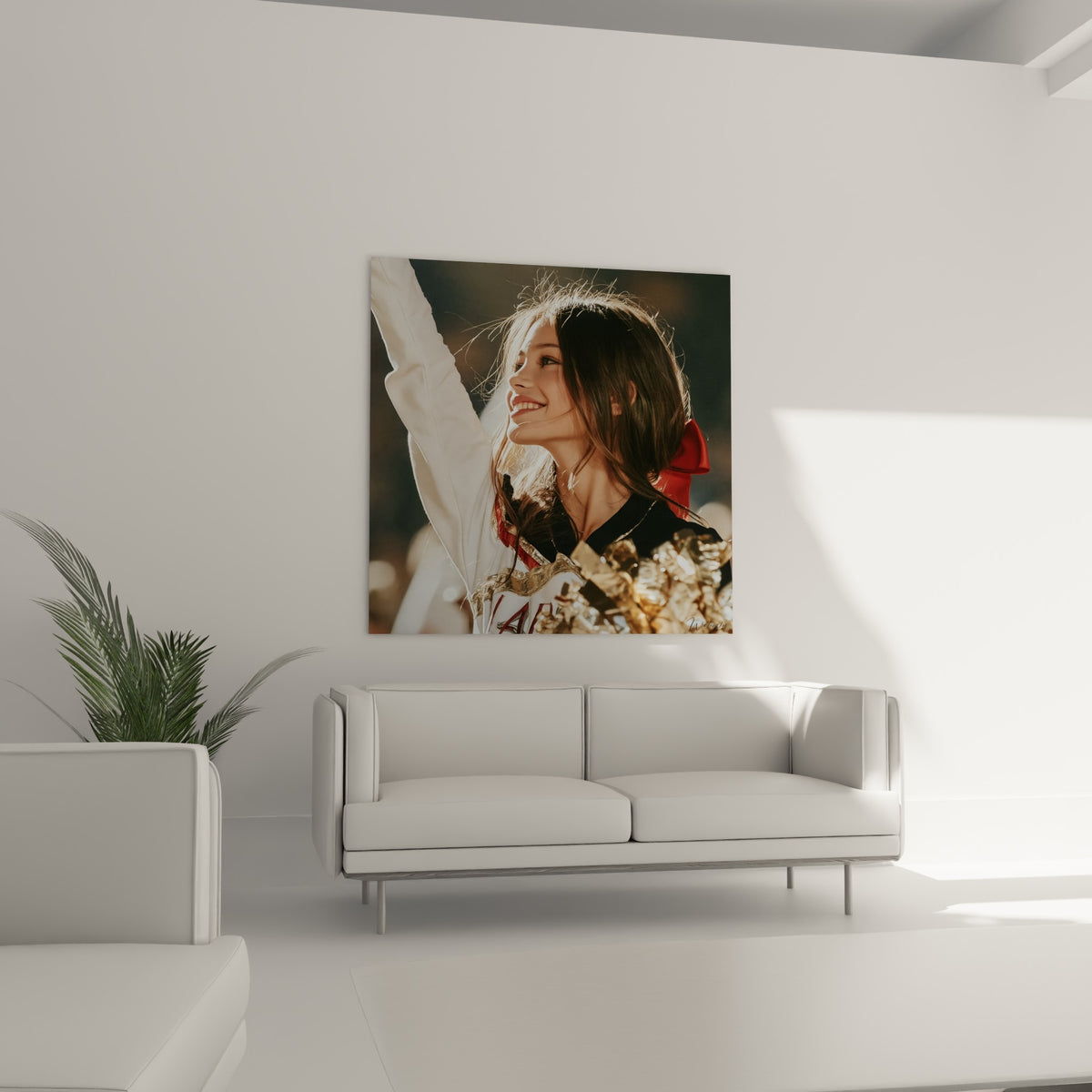 Jeune cheerleader en uniforme blanc et or, tableau accroché au-dessus d'un canapé dans un salon lumineux