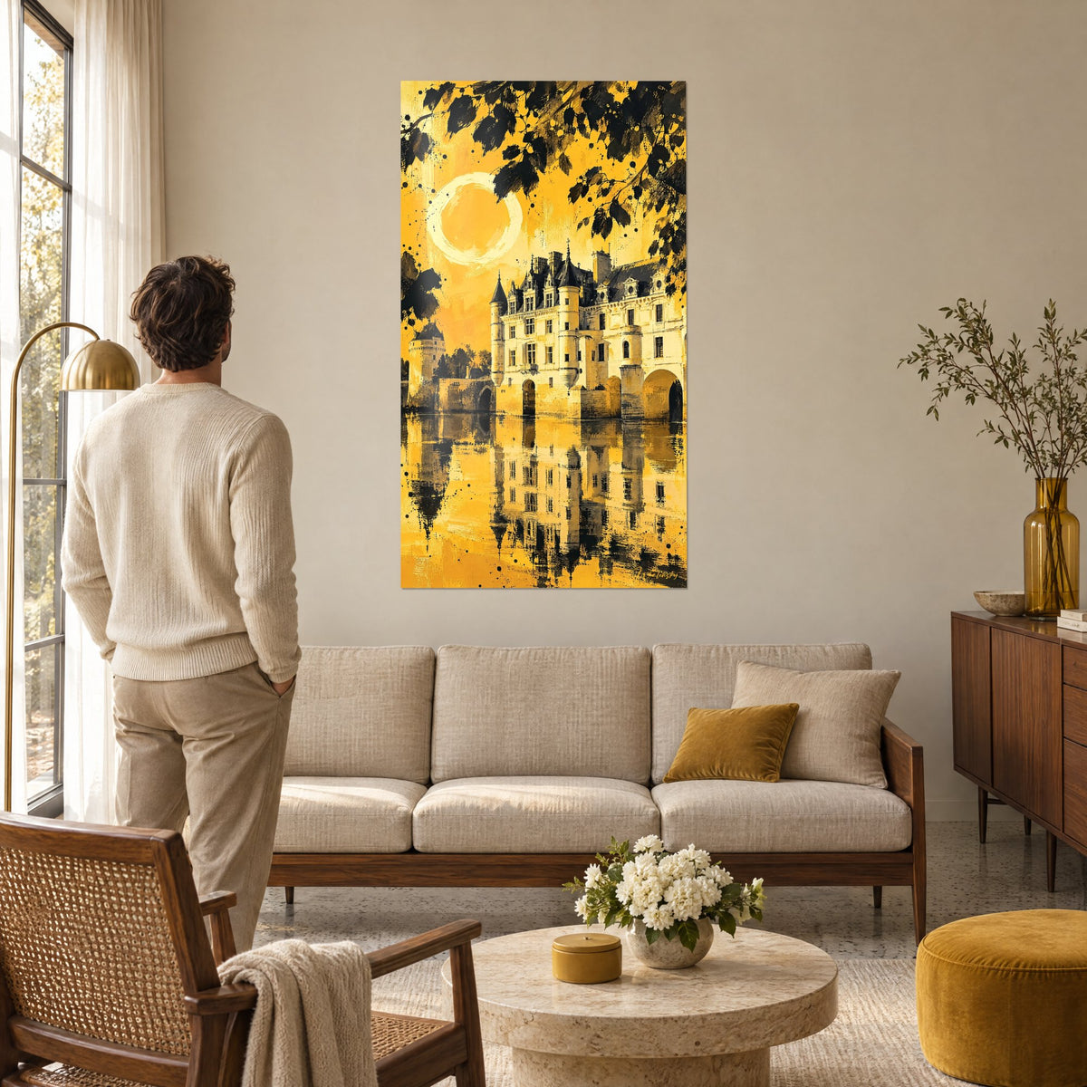 Tableau Château de Chenonceau doré, tours ivoire et reflets sur l'eau, au-dessus d'un canapé dans un salon lumineux