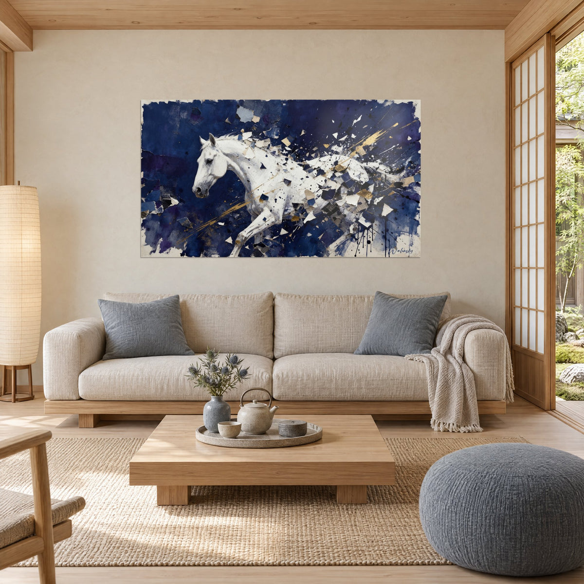 Tableau cheval blanc au galop dans des éclats de papier bleu marine et dorés, au-dessus d'un canapé dans un salon lumineux