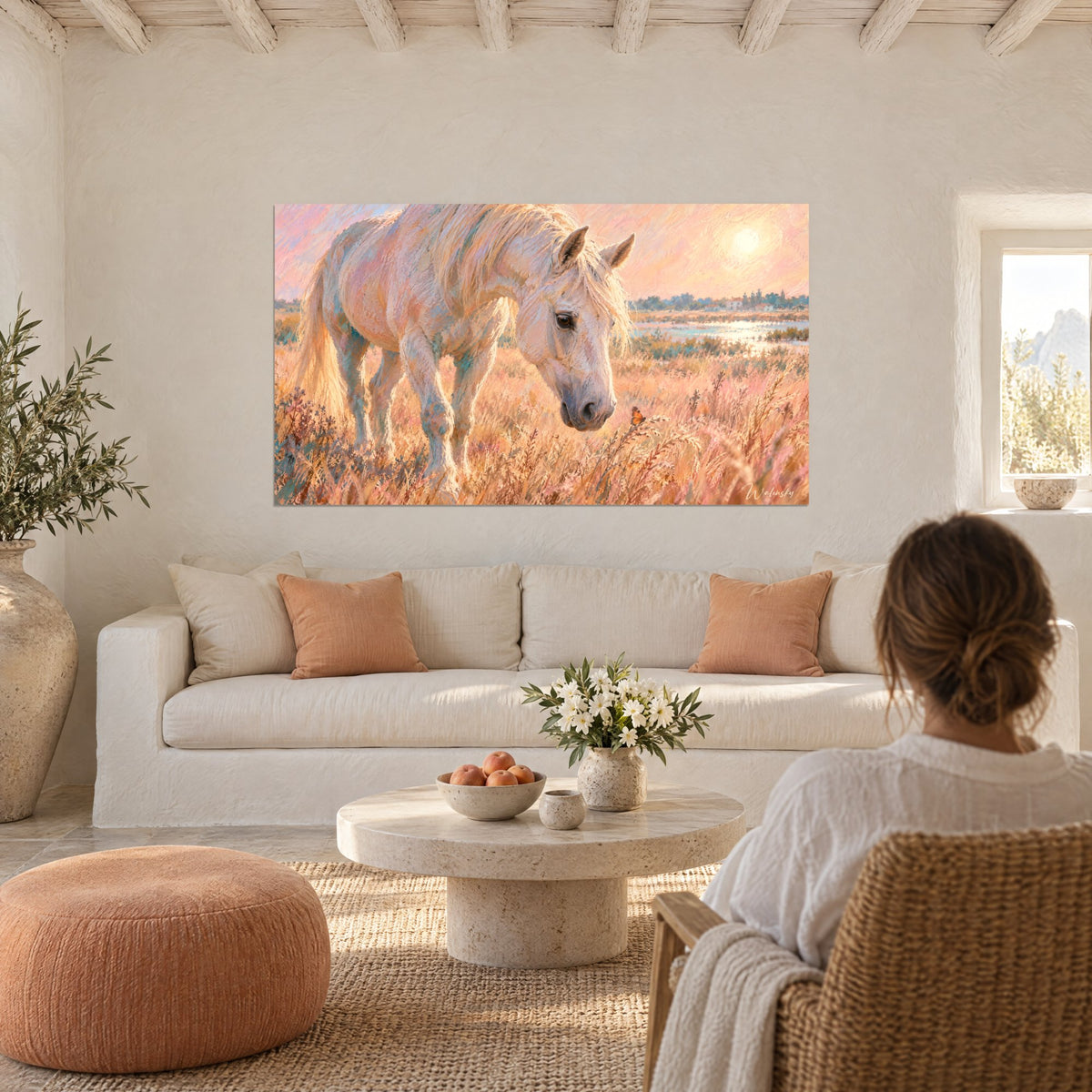 Tableau cheval blanc la tête baissée dans des herbes dorées, ciel rose et soleil pâle, au-dessus d'un canapé dans un salon lumineux