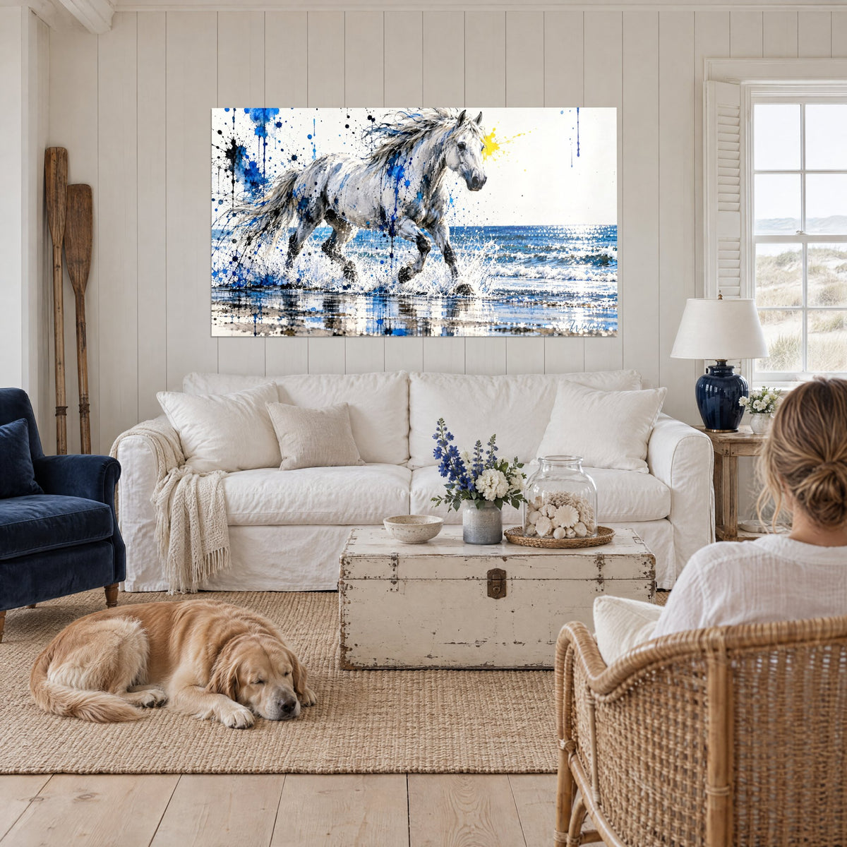 Quadro cavallo bianco dalla criniera argentata che galoppa tra le onde, spruzzi blu, sopra un divano in un soggiorno luminoso