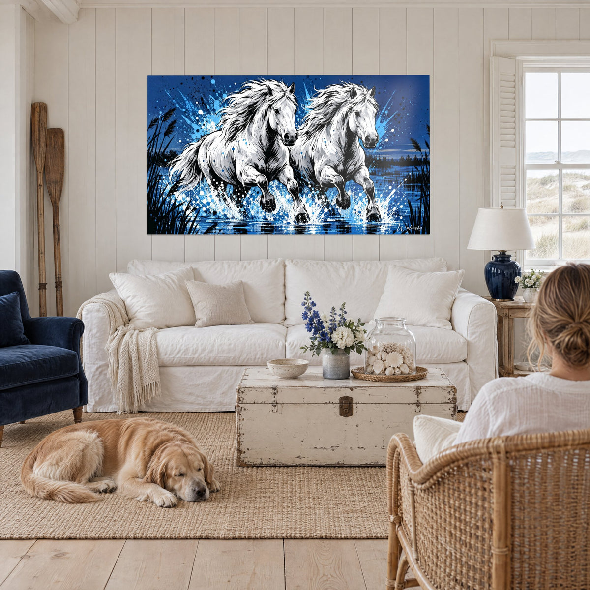 Tableau deux chevaux blancs au galop dans l'eau, éclaboussures bleu roi et noires, au-dessus d'un canapé dans un salon lumineux