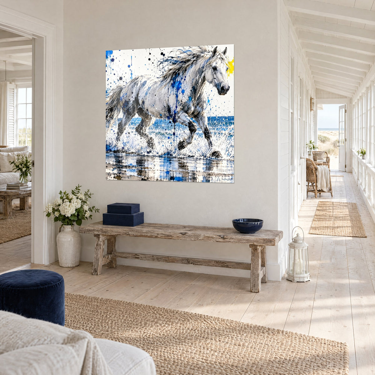 Tableau étalon gris perle lancé au galop, crinière argentée, éclaboussures indigo, sur un mur blanc d'entrée en bord de mer