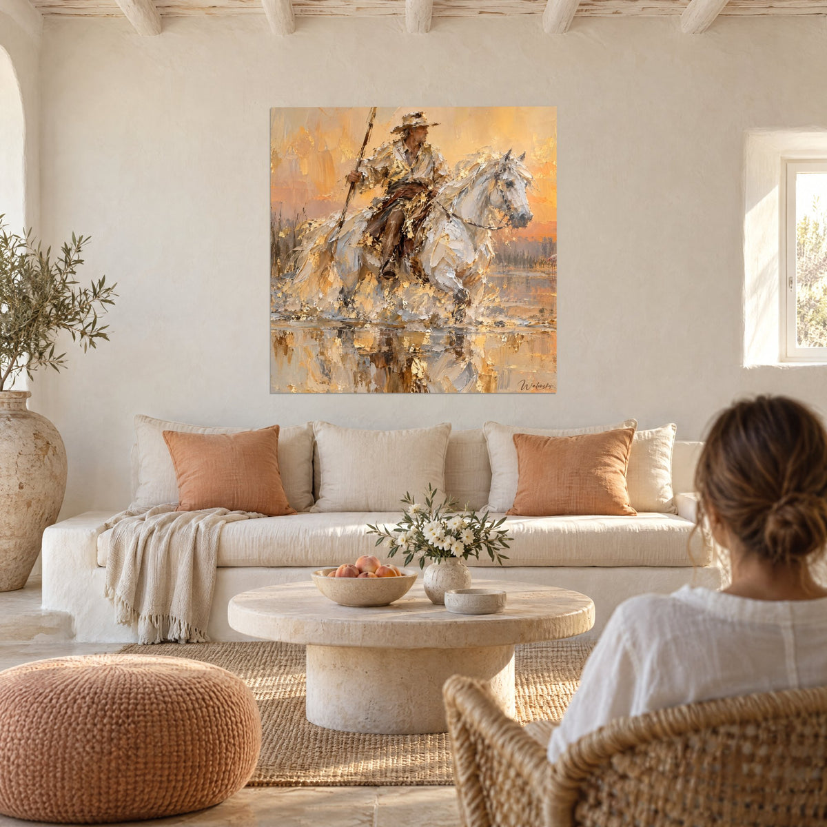 Tableau gardian en chapeau sur cheval blanc, traversée d'étang or et orangé, femme de dos, au-dessus d'un canapé dans un salon lumineux
