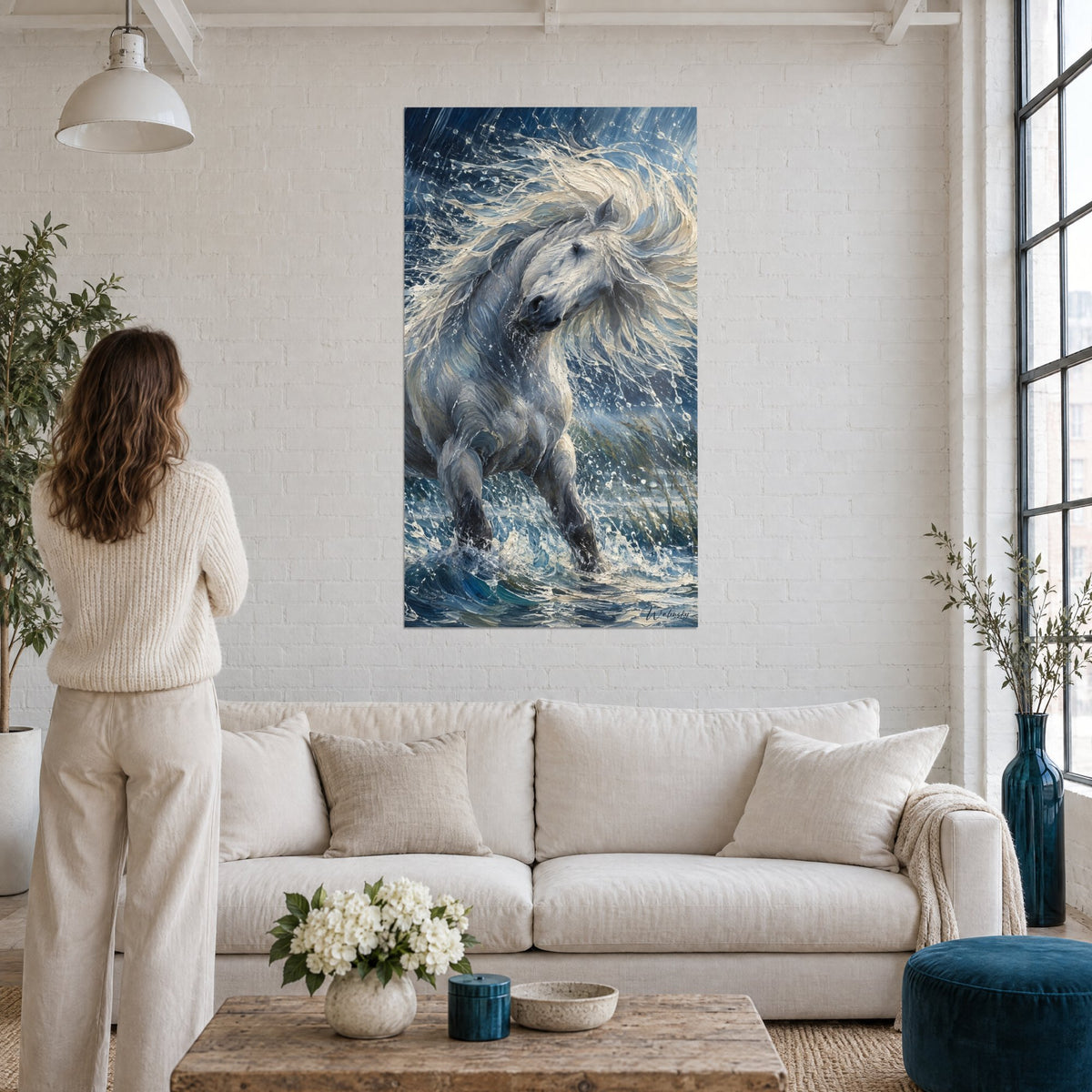 Tableau cheval blanc à la crinière crème ruisselante, éclaboussures bleu nuit, femme de dos, au-dessus d'un canapé dans un salon lumineux