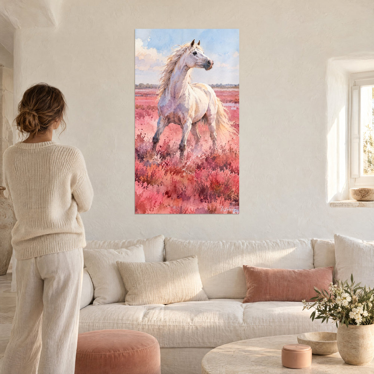 Tableau cheval blanc crinière dorée dans une lande rose et corail, deux personnes de dos, au-dessus d'un canapé dans un salon lumineux