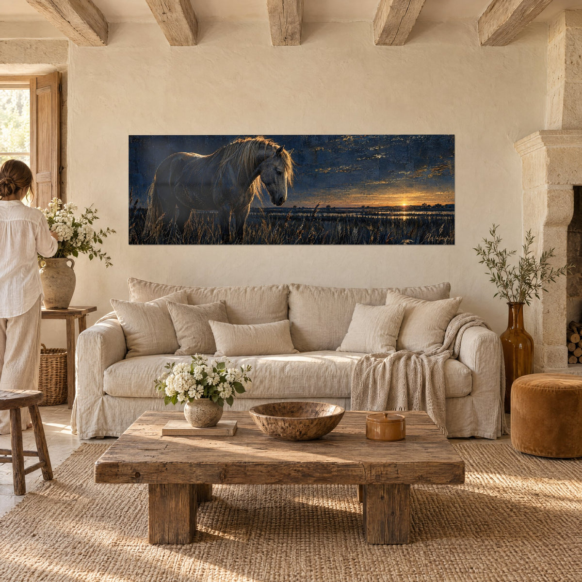 Tableau cheval gris crinière dorée, ciel bleu nuit et soleil orange, herbes sèches, au-dessus d'un canapé dans un salon lumineux