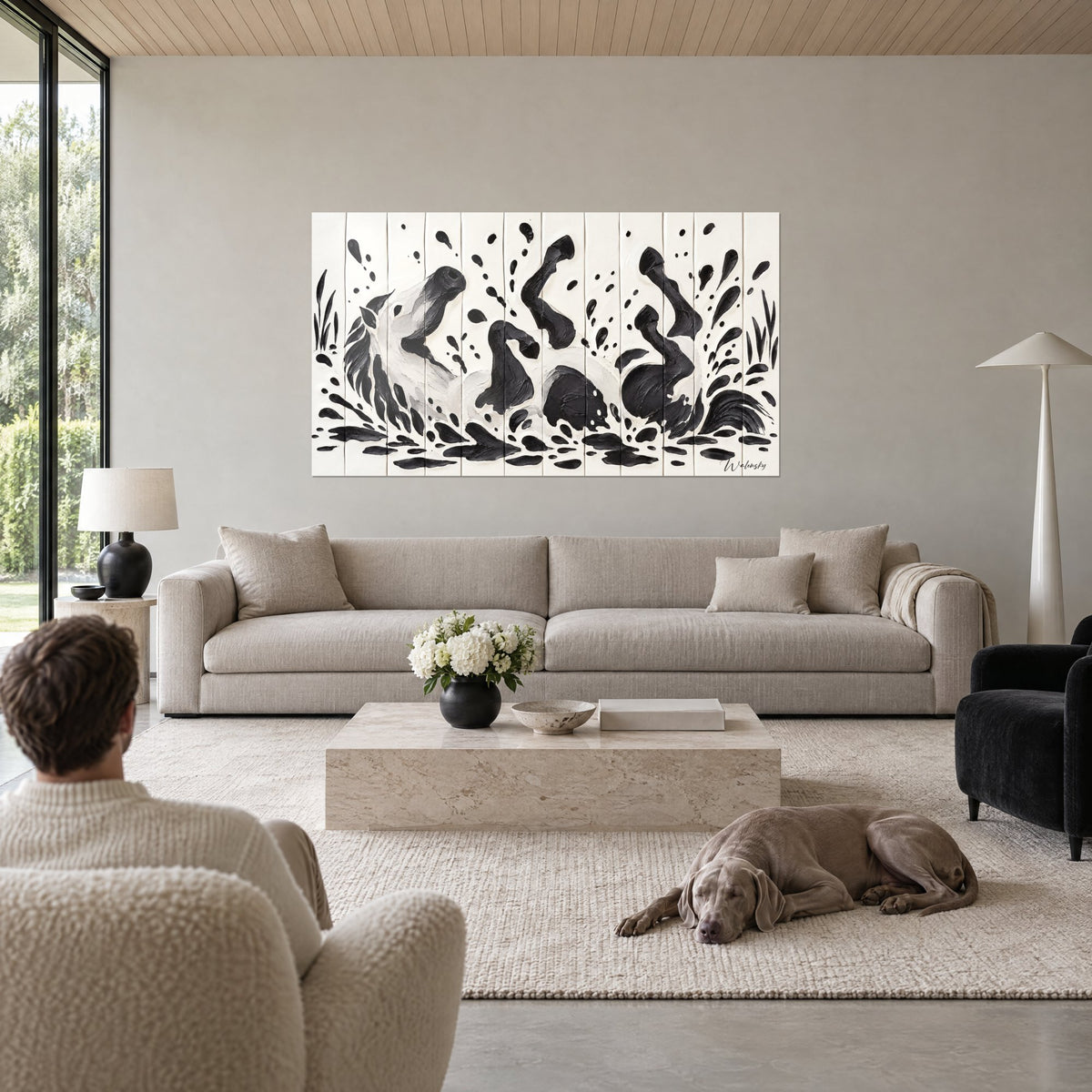 Tableau étalon blanc renversé sur le dos, sabots noirs en l'air et éclaboussures d'encre, au-dessus d'un canapé dans un salon lumineux