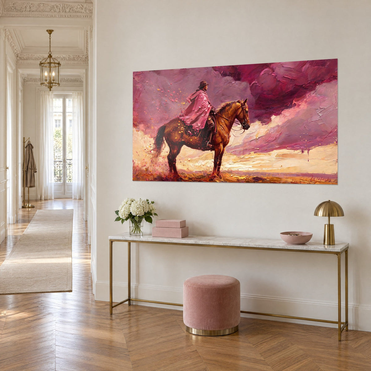 Cuadro de un gaucho con capa rosa montado en un caballo marrón, cielo berenjena y arena dorada, sobre una consola dorada en la entrada