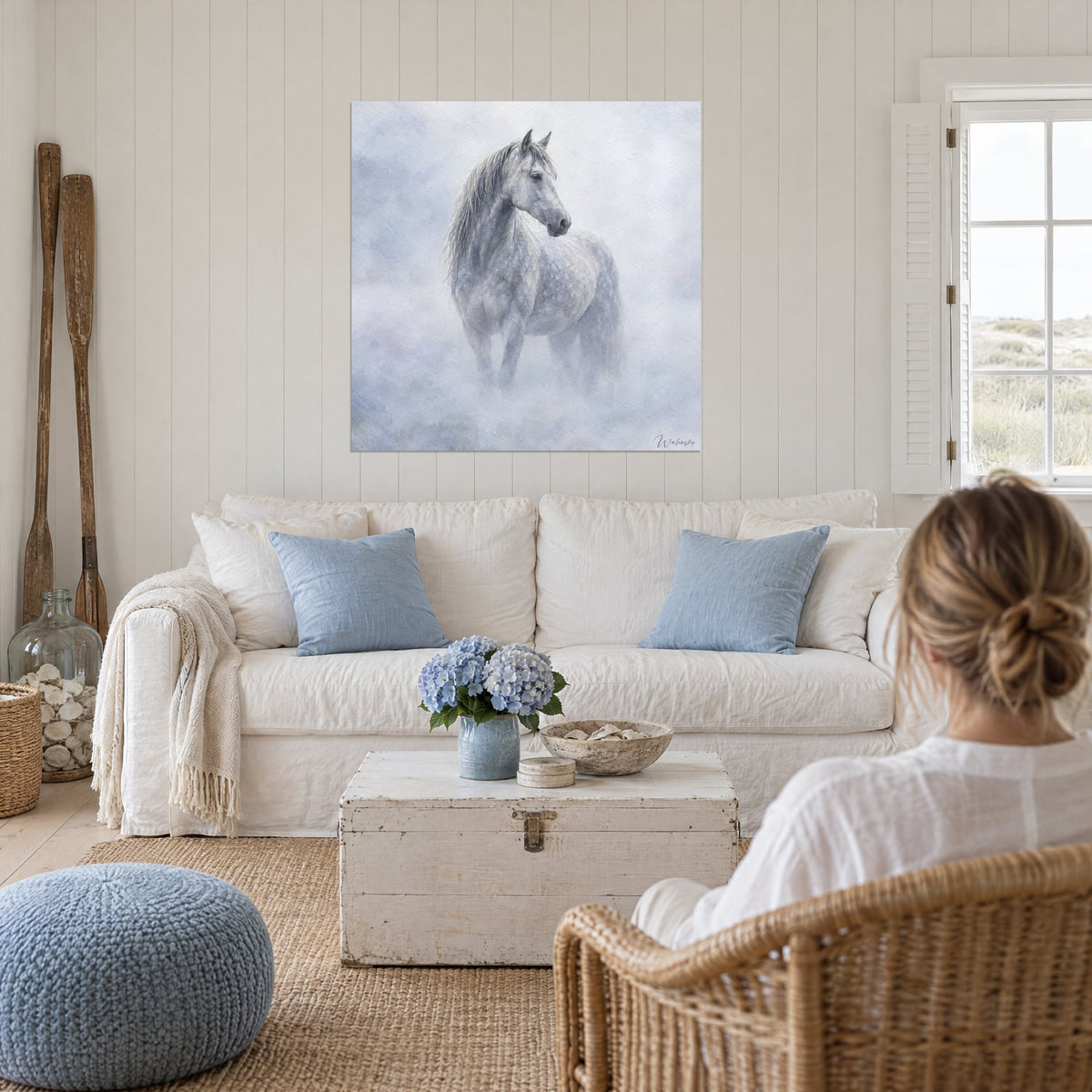 Tableau étalon gris pommelé dans la brume bleutée, mèche mouillée, au-dessus d'un canapé dans un salon lumineux
