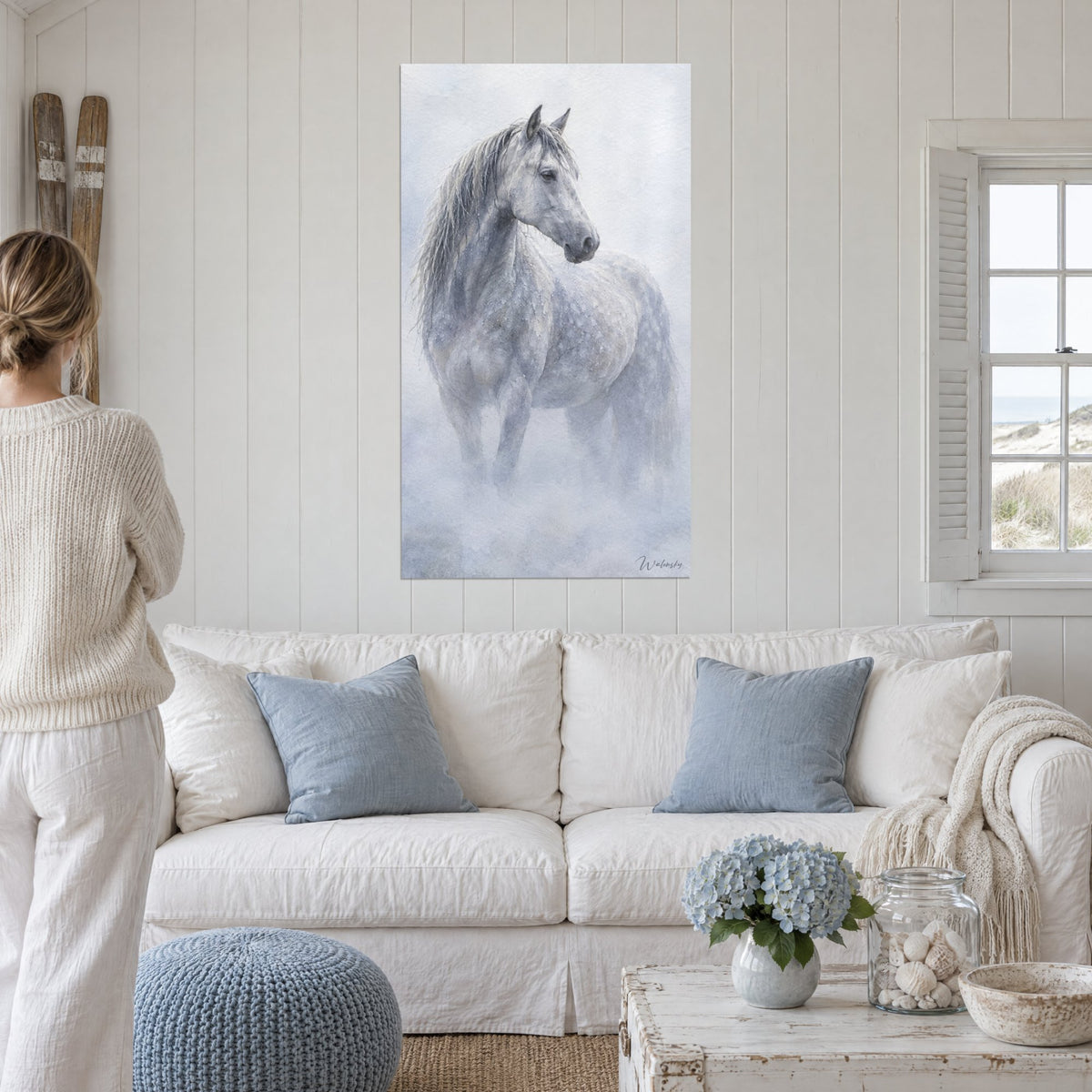 Tableau cheval gris pommelé dans la brume, crinière argentée et fond bleu givré, au-dessus d'un canapé dans un salon lumineux
