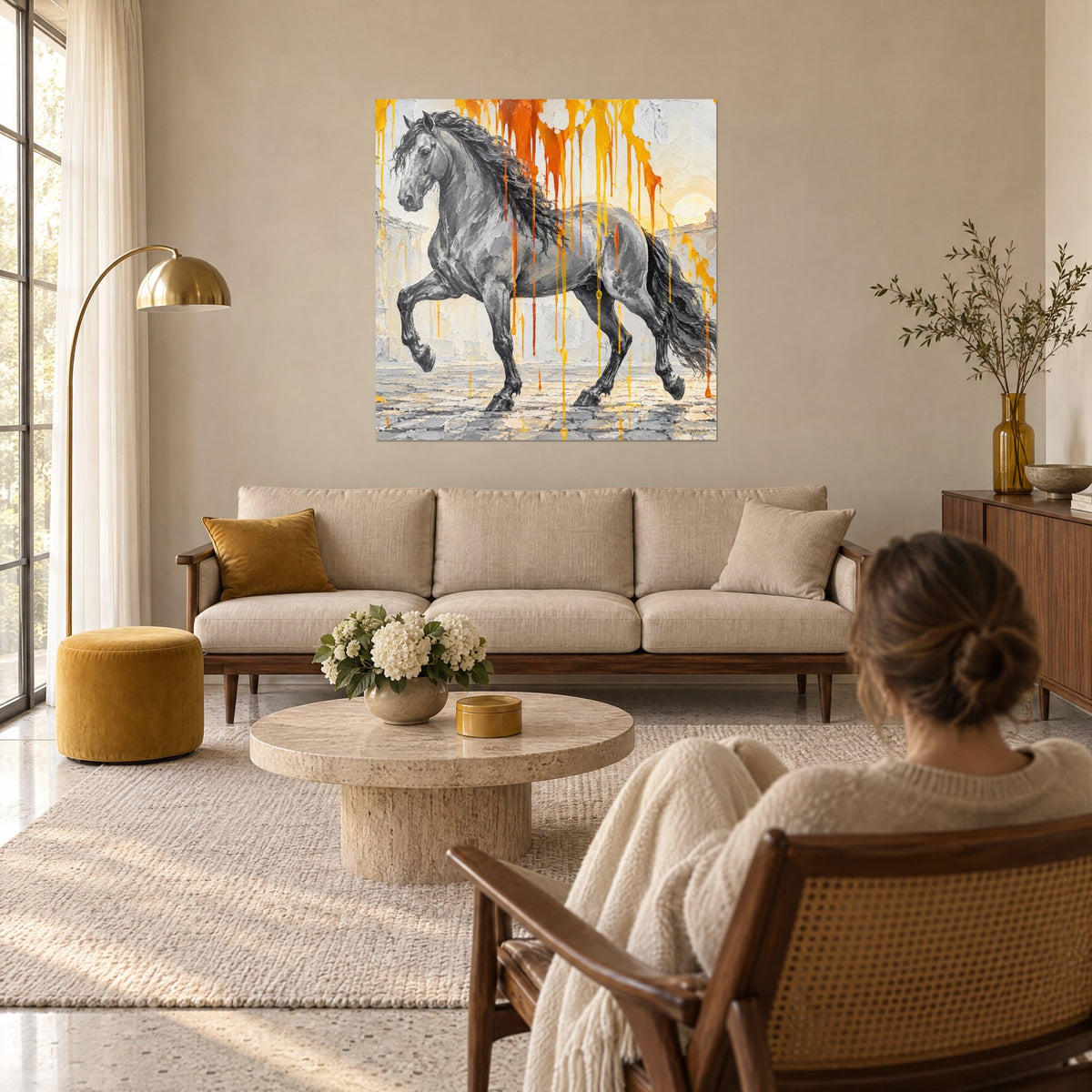Tableau étalon gris piaffant, crinière noire et coulures orange ocre, accroché au-dessus d'un canapé dans un salon lumineux