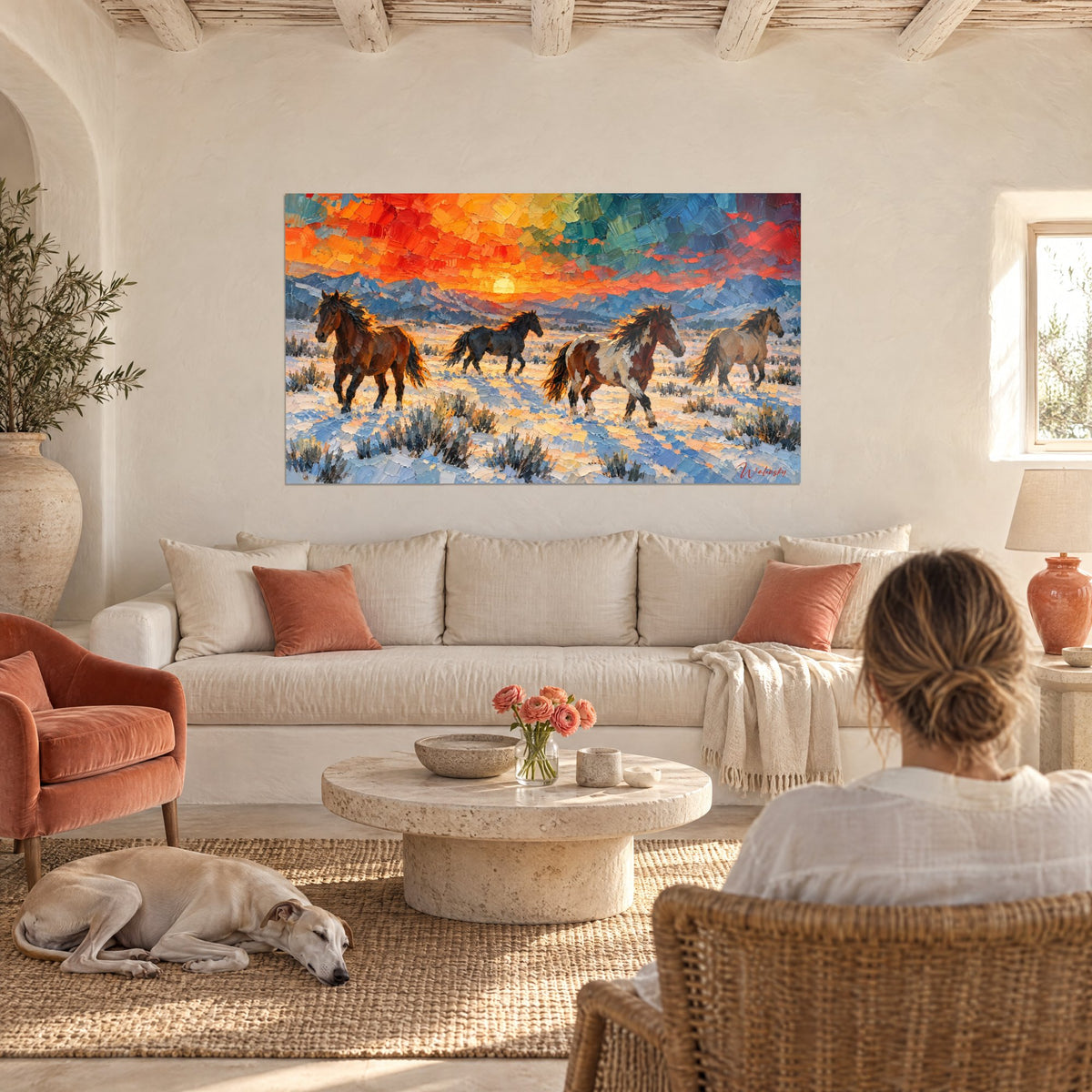 Tableau quatre mustangs au galop, robes baie et noire sur neige bleutée, ciel orange, au-dessus d'un canapé dans un salon lumineux