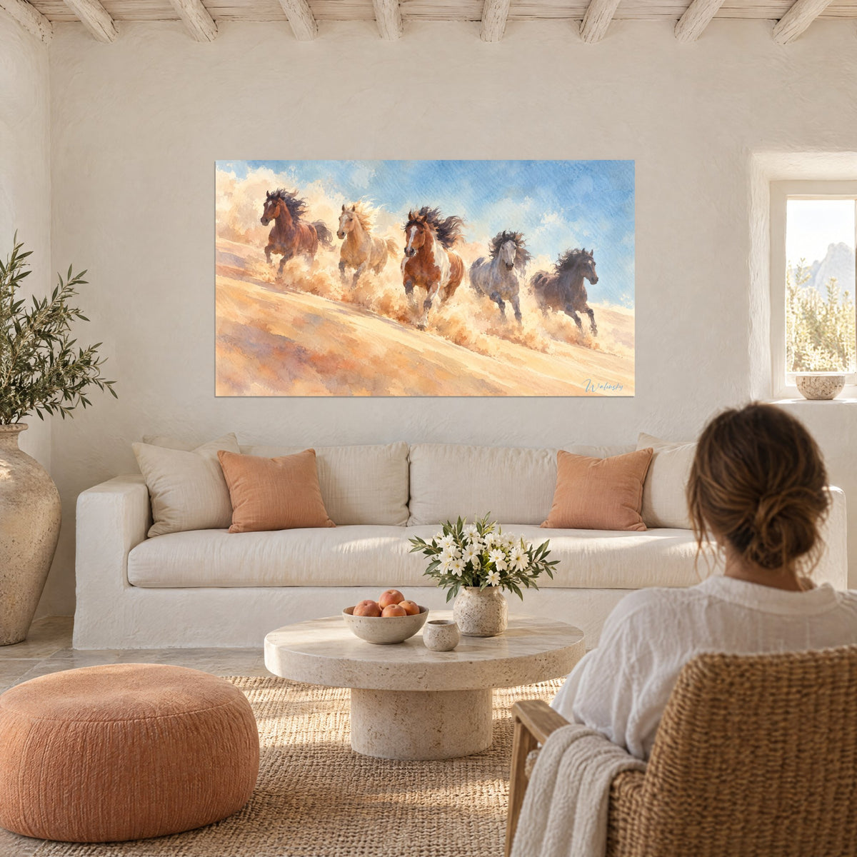 Tableau mustangs au galop soulevant une poussière ocre, bleu ciel et crinières noires, au-dessus d'un canapé dans un salon lumineux