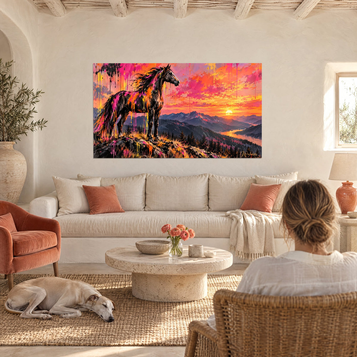 Tableau étalon noir éclaboussé de rose fluo et d'orange, couchant doré sur les montagnes, au-dessus d'un canapé dans un salon lumineux
