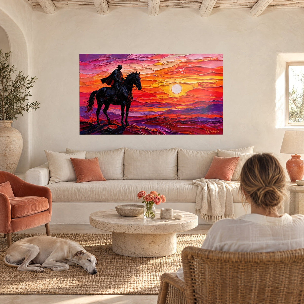 Cuadro de un jinete negro a caballo frente al sol pálido, cielo naranja y violeta en empastes gruesos, sobre un sofá en un salón luminoso