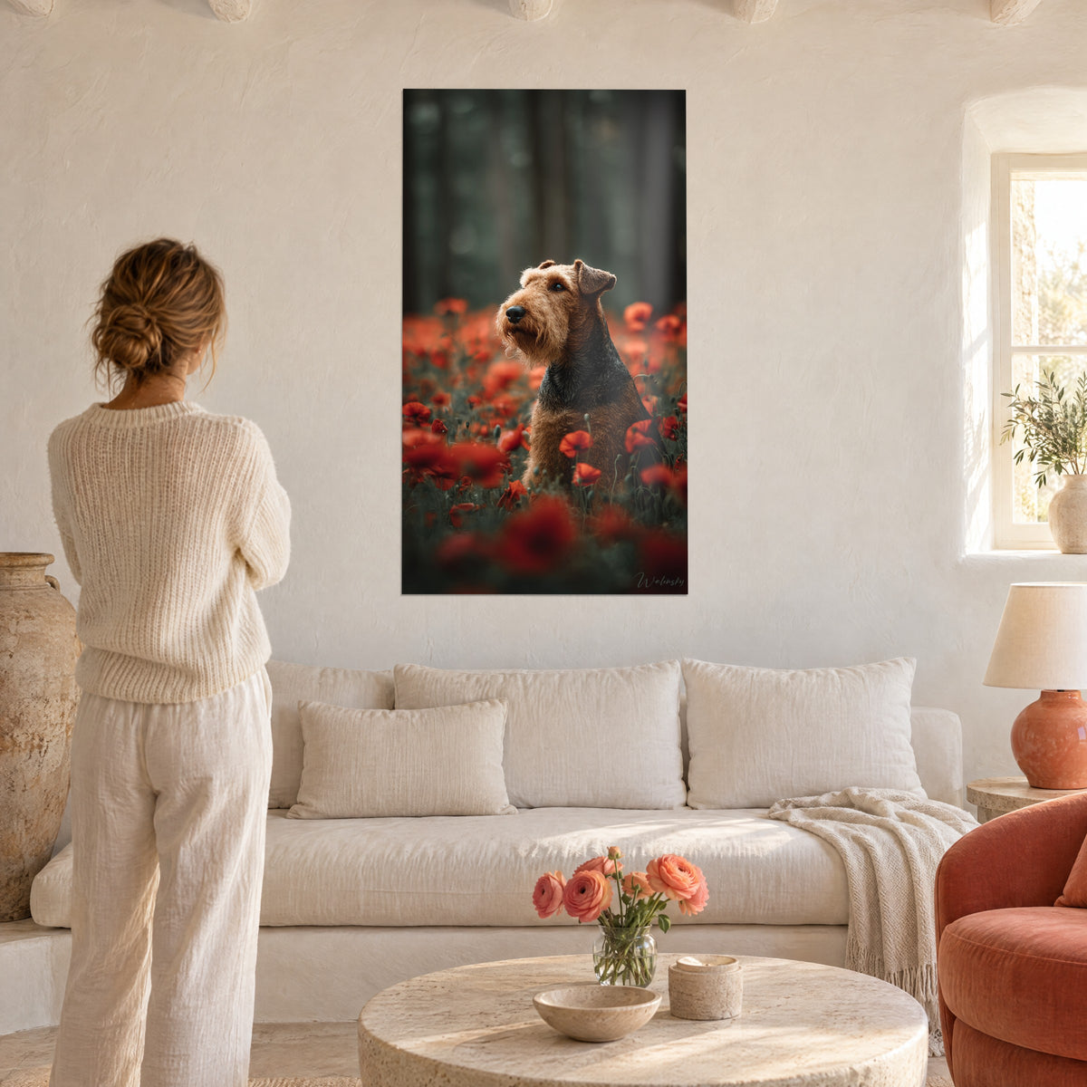 Πίνακας Airedale terrier με τρίχωμα ξανθοκαφέ και μαύρη ράχη, καθισμένο ανάμεσα σε κόκκινες παπαρούνες, πάνω από καναπέ σε φωτεινό σαλόνι
