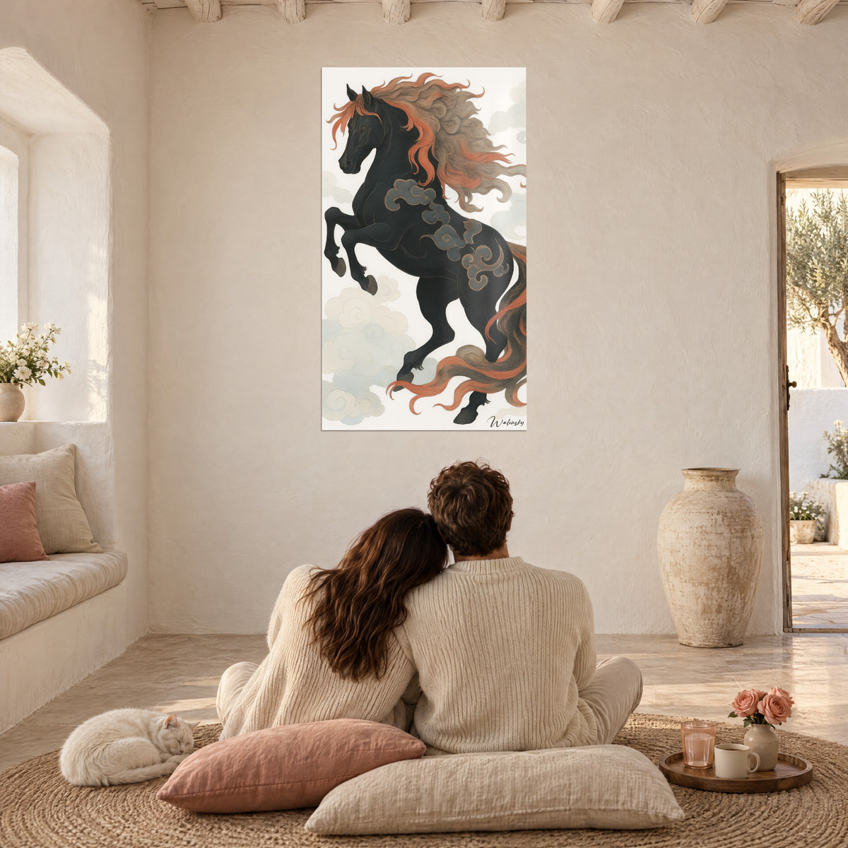 Cuadro de un caballo de ébano con nubes bordadas, mechones naranjas y topo, pareja de espaldas sentada sobre cojines, gato, casa mediterránea