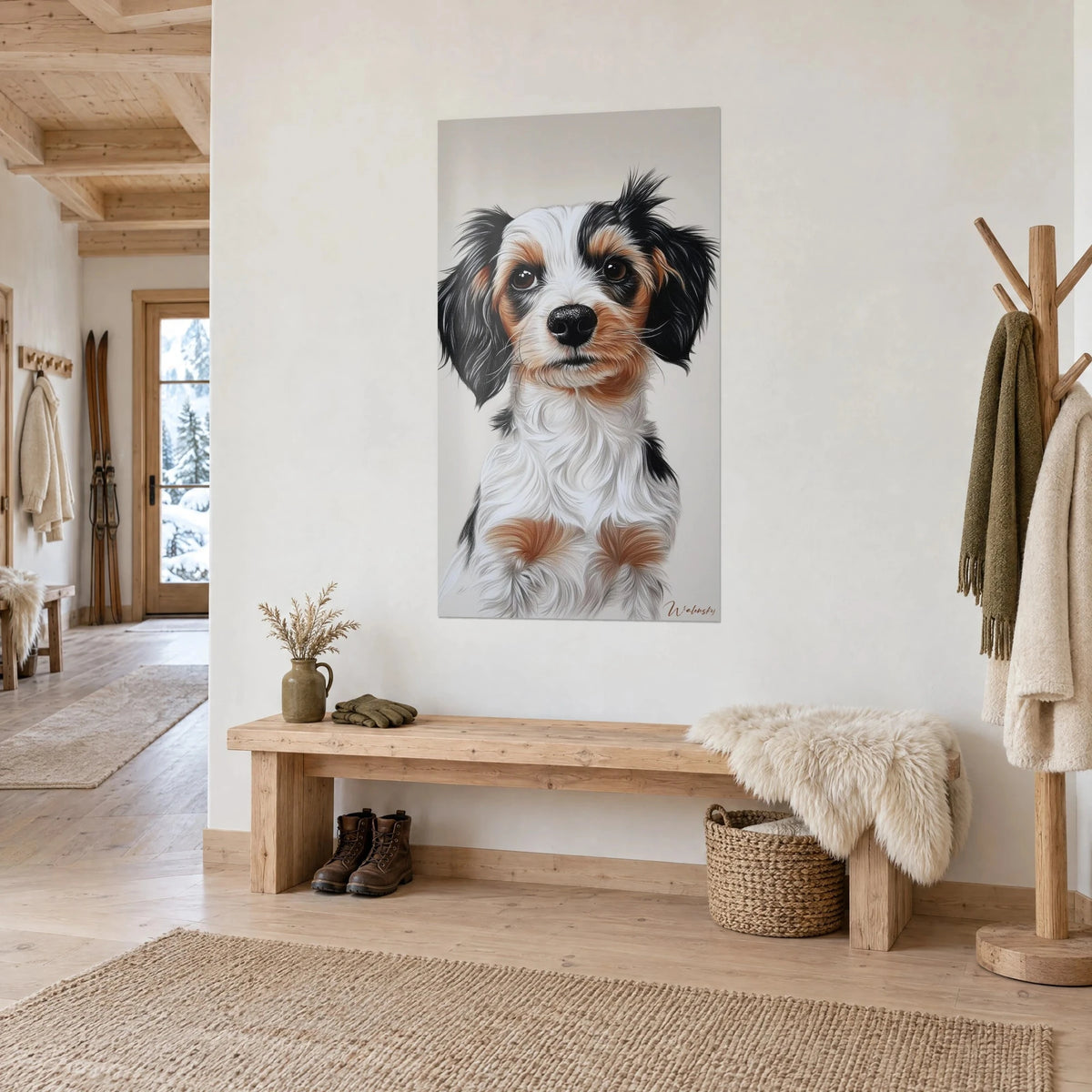 Quadro di un piccolo cane tricolore dallo sguardo marrone brillante, tartufo nero e manto crema, su una parete chiara da chalet