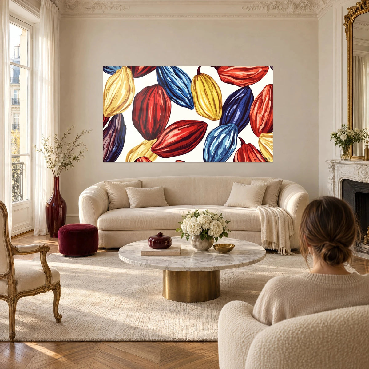 Gemälde mit roten, blauen und gelben Kakaofrüchten in lebendiger Illustration, über einem Sofa in einem hellen Wohnzimmer
