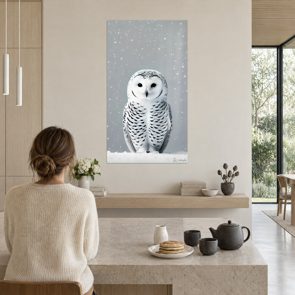 Schilderij sneeuwuil met een donkere blik, crèmekleurige veren met ebbenhouten strepen, sneeuwvlokken in de lucht, beige muur van een open keuken