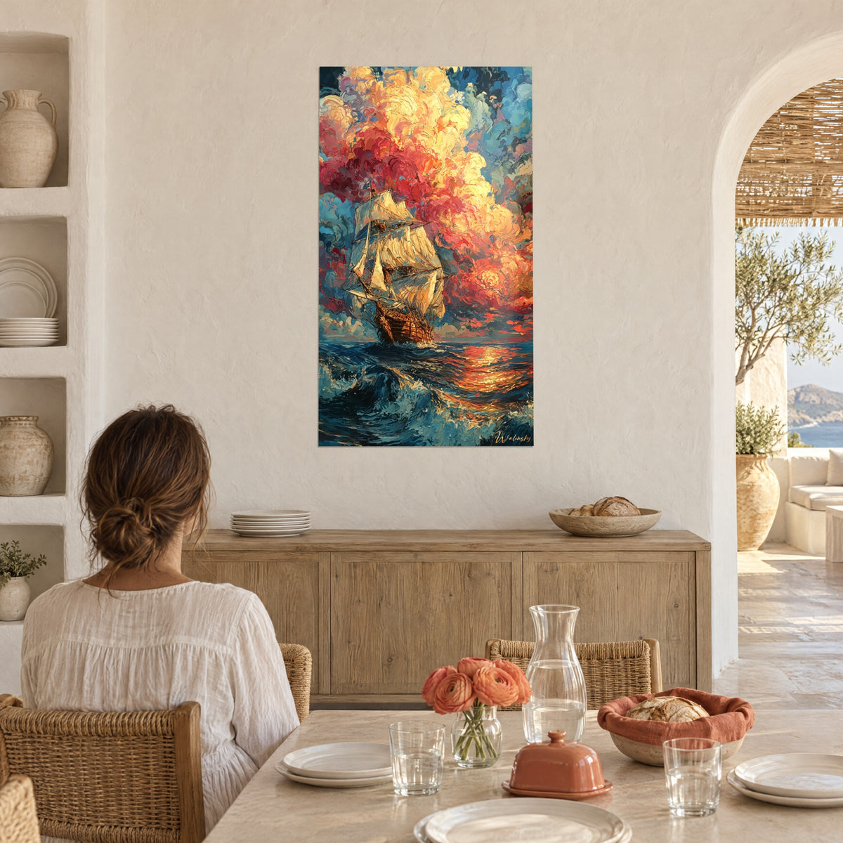 Cuadro de un antiguo velero lanzado sobre olas azur, nubes escarlata y doradas, pareja de espaldas junto a una mesa puesta en una casa blanca