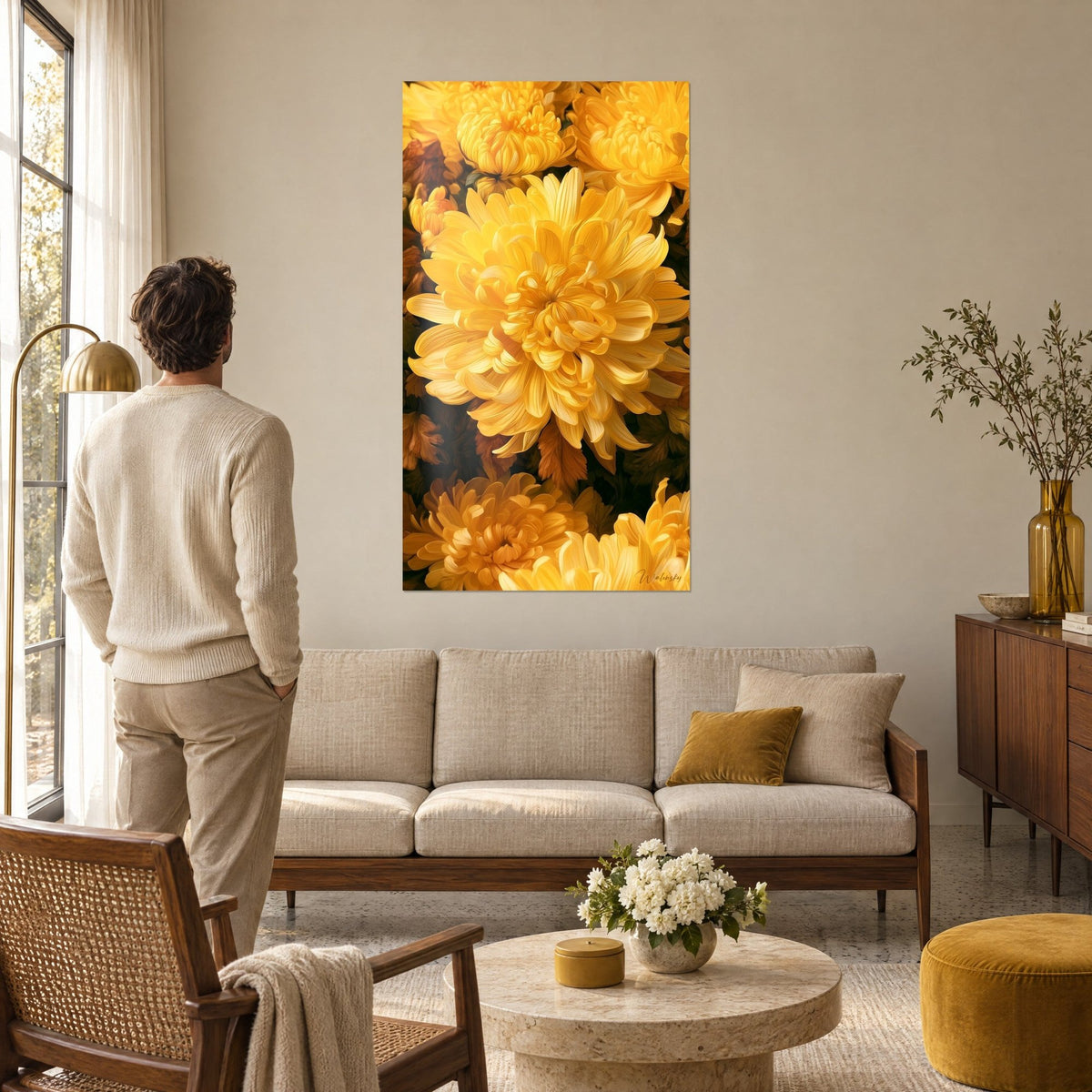 Wall art of a yellow chrysanthemum with wavy petals on a brown background, man seen from behind, above a sofa in a bright living room