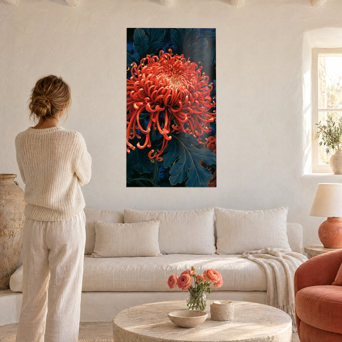 Cuadro crisantemo coral con pétalos en volutas sobre hojas azul noche, encima de un sofá en un salón luminoso