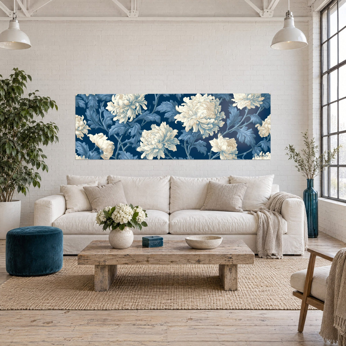 Tableau chrysanthèmes ivoire en frise sur fond bleu marine, feuillage gravé bleu ciel, au-dessus d'un canapé dans un salon lumineux