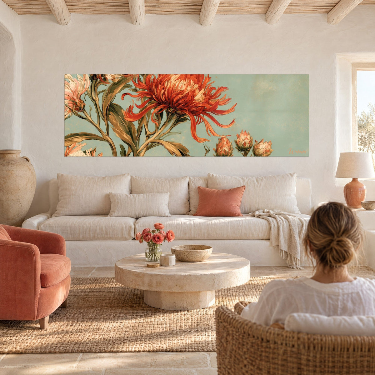 Tableau chrysanthème rouge corail aux pétales effilés sur fond céladon, femme de dos, au-dessus d'un canapé dans un salon lumineux