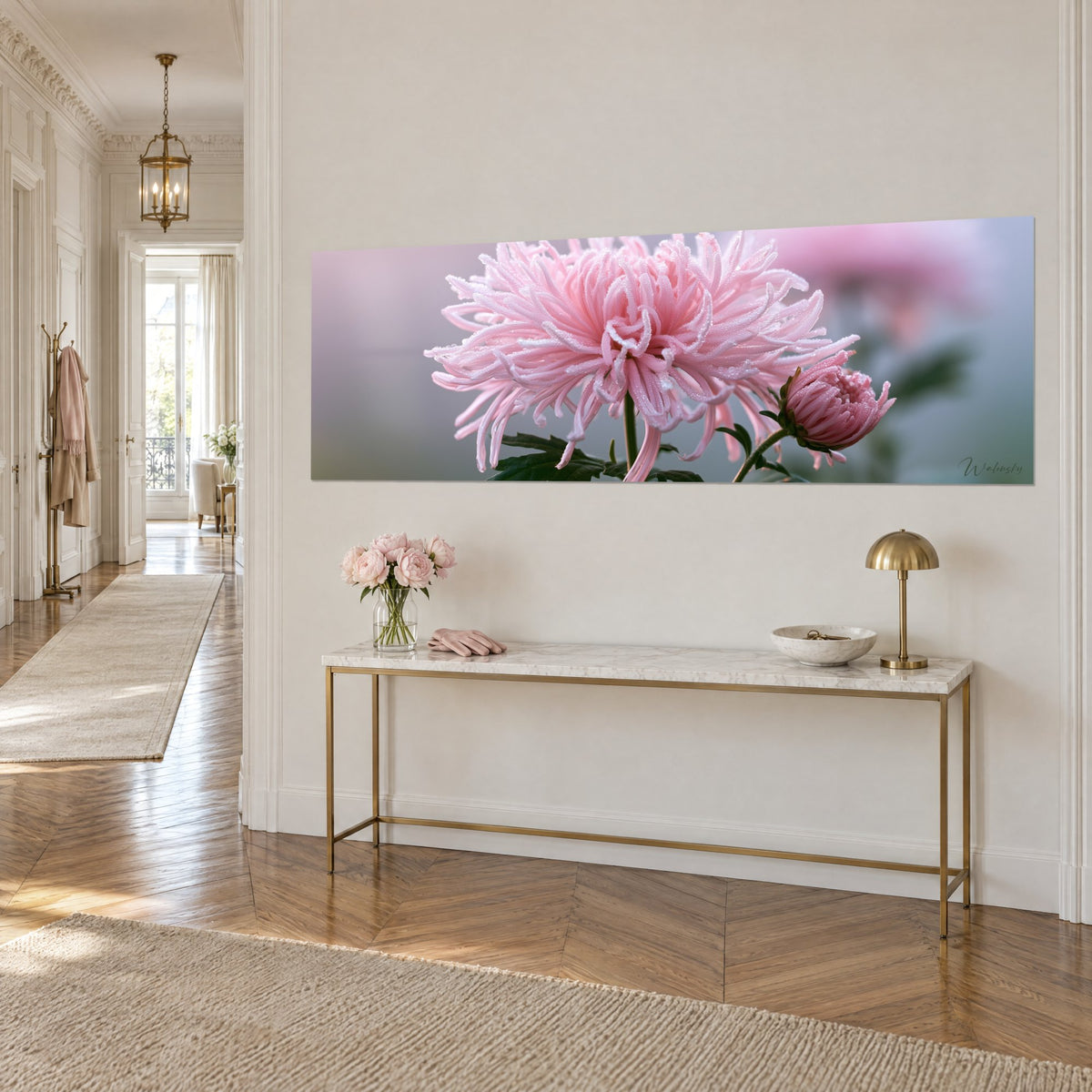 Wall art pale pink aster bloom, recessed bud and dark green leaves beaded with droplets, on a gilded console in the entryway