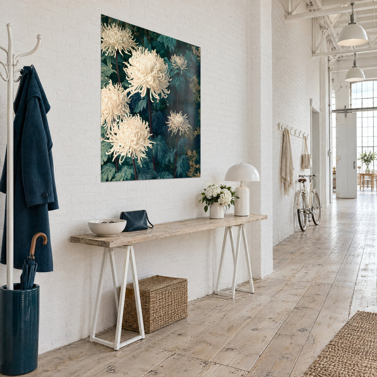 Wall art with cream pompom autumn flowers, deep blue-green foliage, three-quarter view on a white wall, light wood console