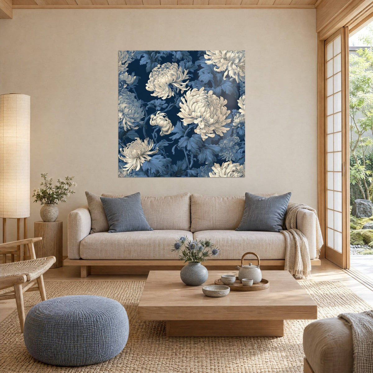 Tableau chrysanthèmes ivoire aux pétales filiformes sur fond bleu marine, feuillage bleu ciel, au-dessus d'un canapé dans un salon lumineux