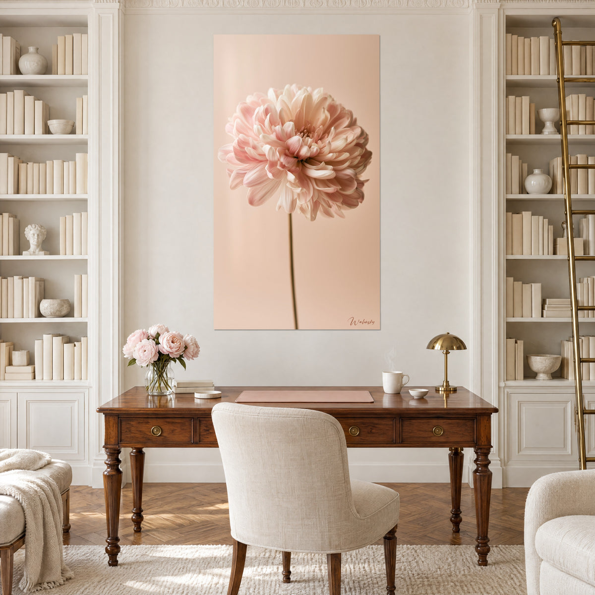 Quadro corolla rosa confetto con petali avorio su sfondo beige pesca, stelo oliva, appeso tra due librerie di uno studio