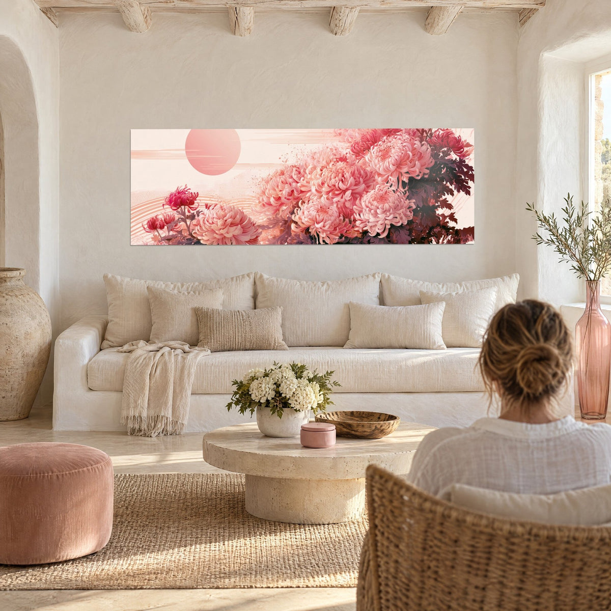 Tableau chrysanthèmes rose poudré et pourpre sous un disque solaire pâle, femme de dos, au-dessus d'un canapé dans un salon lumineux