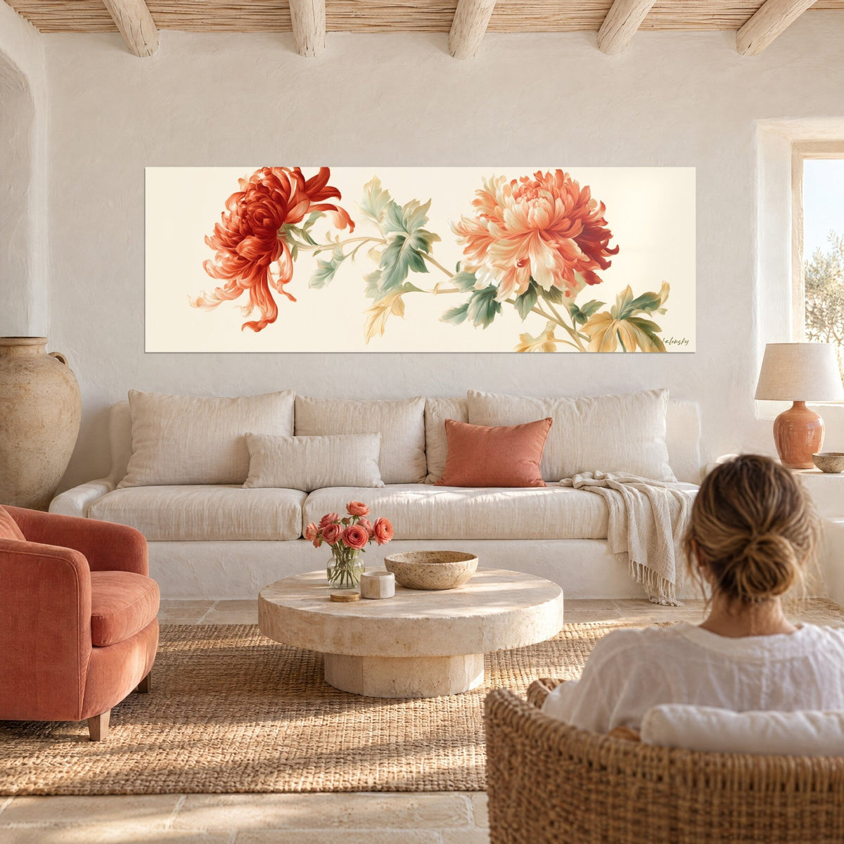 Tableau chrysanthème rouge corail aux pétales filiformes et fleur pêche, feuillage vert sauge, au-dessus d'un canapé dans un salon lumineux