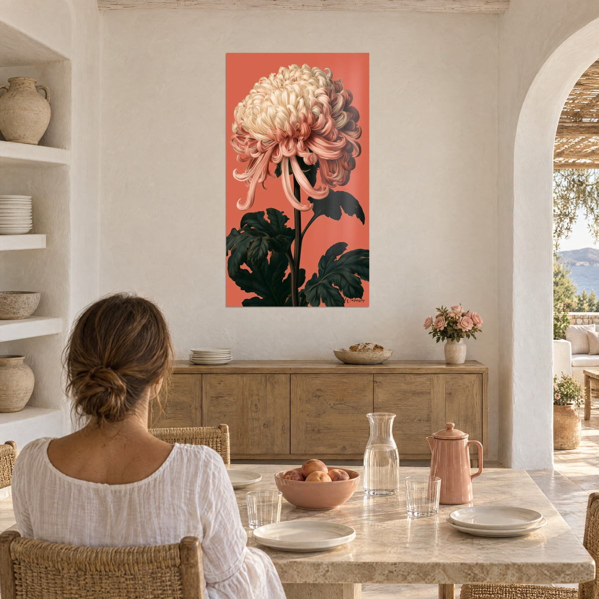 Quadro capolino crema e salmone su sfondo rosso corallo, fogliame verde scuro, donna seduta di spalle a un tavolo, casa mediterranea