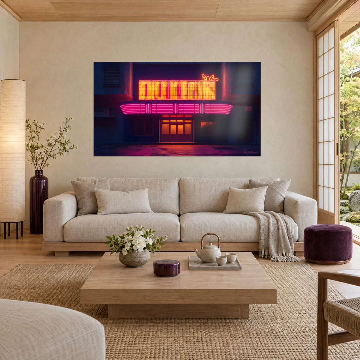 Quadro di una facciata di cinema retrò illuminata da neon giallo arancio e rosa fucsia, sopra un divano in un soggiorno luminoso