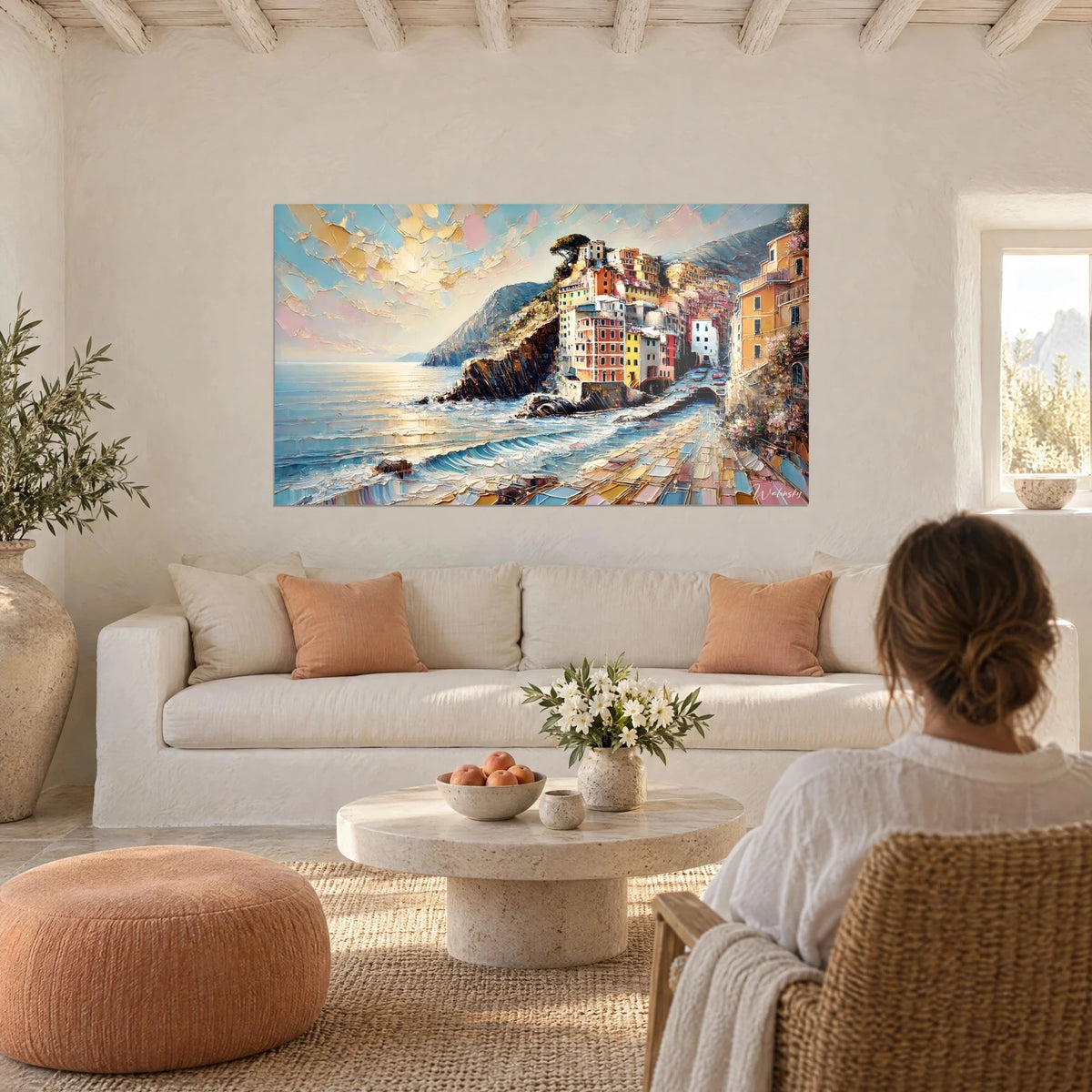 Gemälde einer kolonialen Dorfsiedlung auf einer Klippe, ockerfarbene und korallenrote Fassaden, türkisfarbenes Meer, über einem Sofa in einem hellen Wohnzimmer