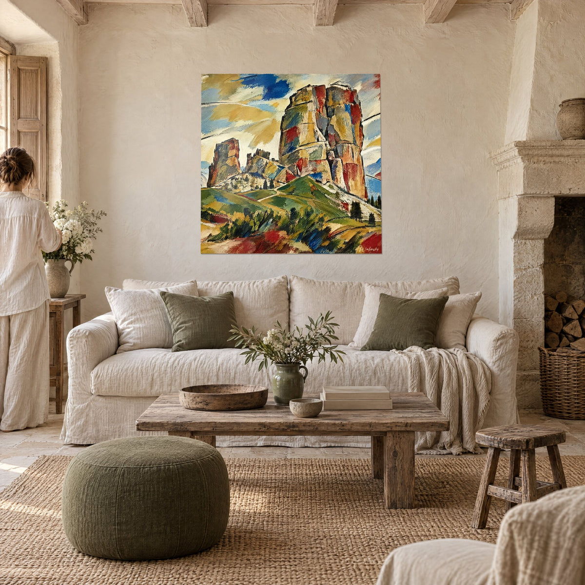 Tableau tours rocheuses ocre et rouge brique, ciel bleu cobalt, collines vertes, deux personnes de dos au-dessus d'un canapé dans un salon lumineux