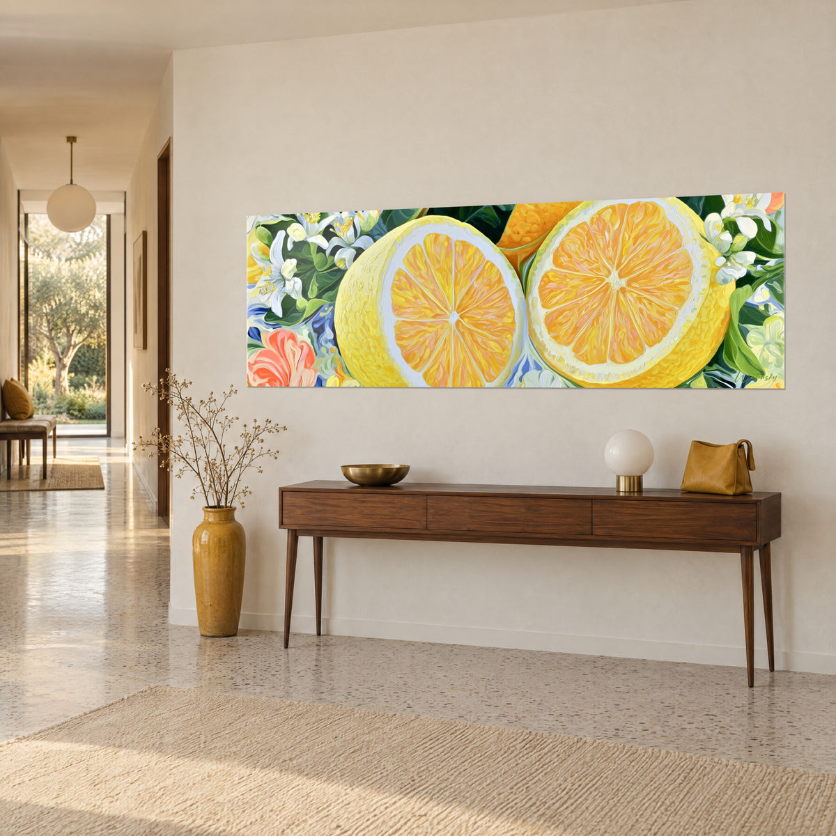 Wall art of a sliced orange with vivid orange segments, dark green foliage and a coral flower, hanging above a wooden console