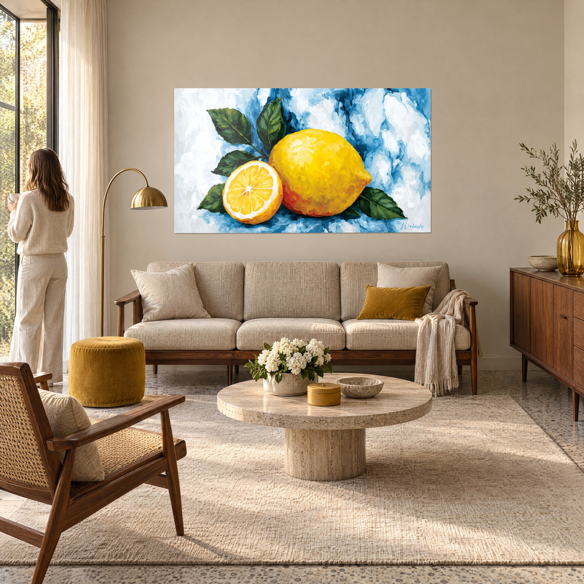 Gemälde einer leuchtend gelben ganzen Zitrone auf blau meliertem Hintergrund, halbe aufgeschnittene Zitrone und grüne Blätter, über einem Sofa in einem hellen Wohnzimmer